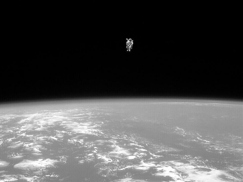 A lone astronaut floating in the vast expanse of space, with the Earth visible in the background.