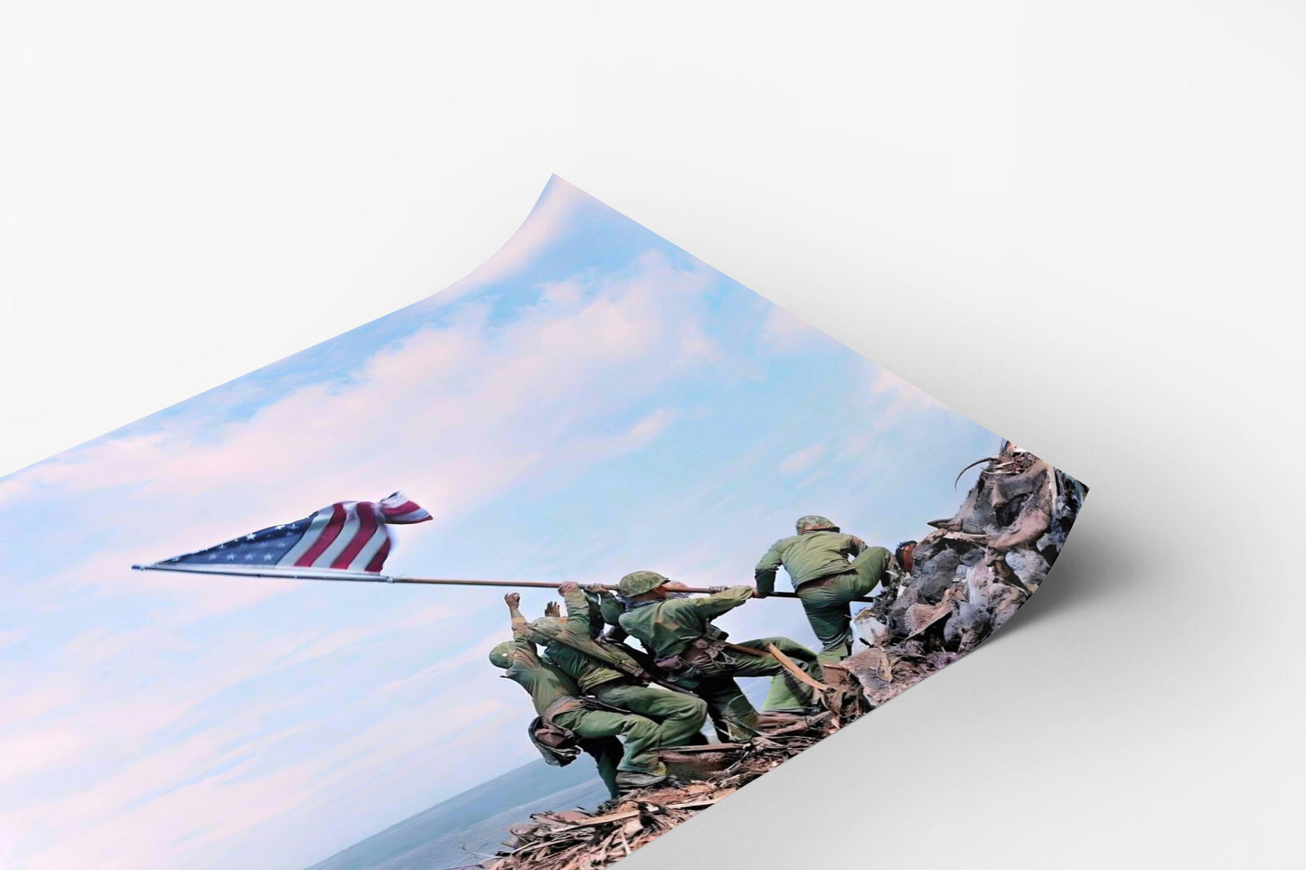 A group of soldiers in green uniforms are working together to raise an American flag on a rocky hill, with a clear blue sky in the background.