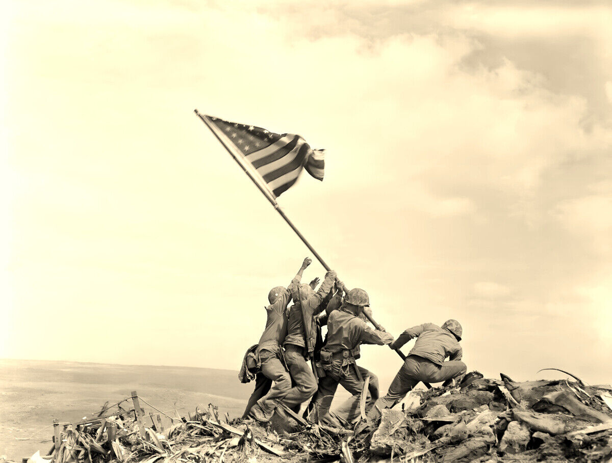 A group of soldiers raising the American flag on a rocky hill, with a cloudy sky in the background.