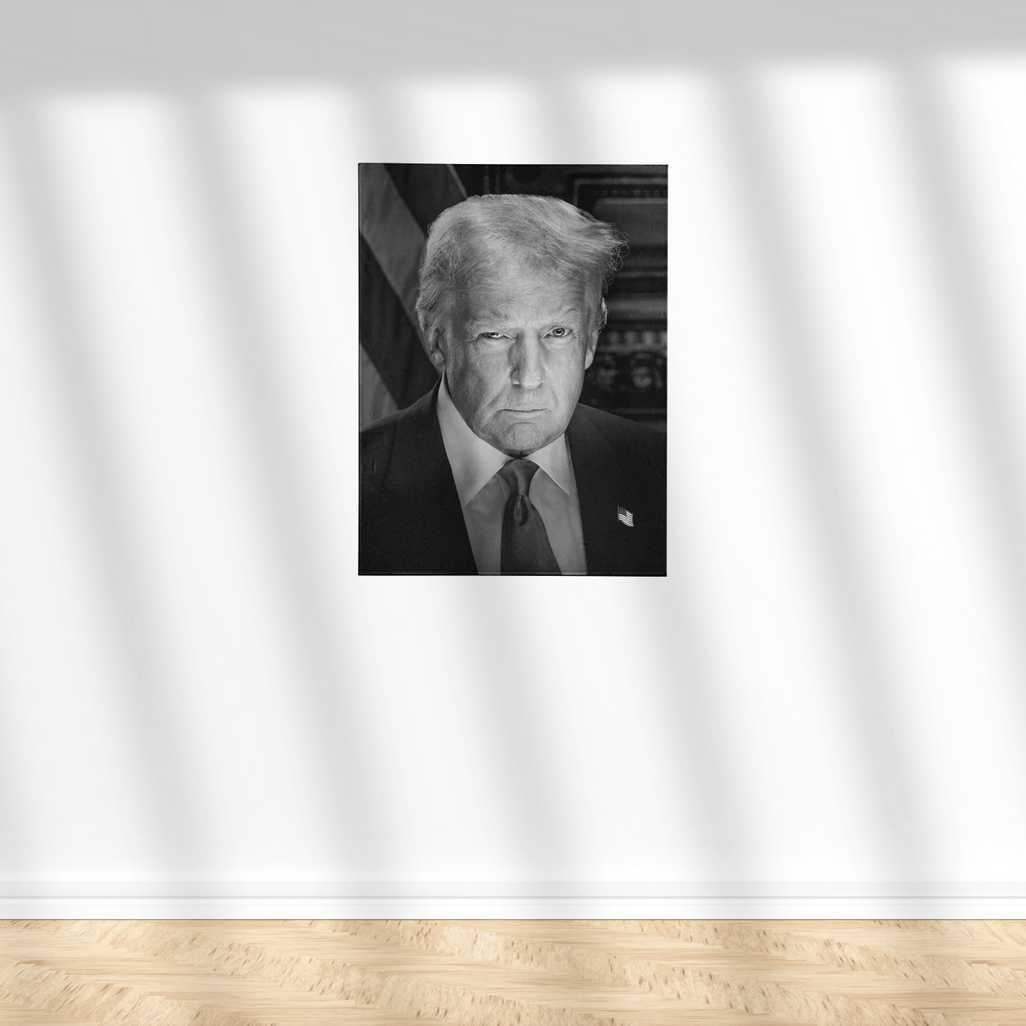 A black and white portrait of a man wearing a suit and tie, standing against a white wall.