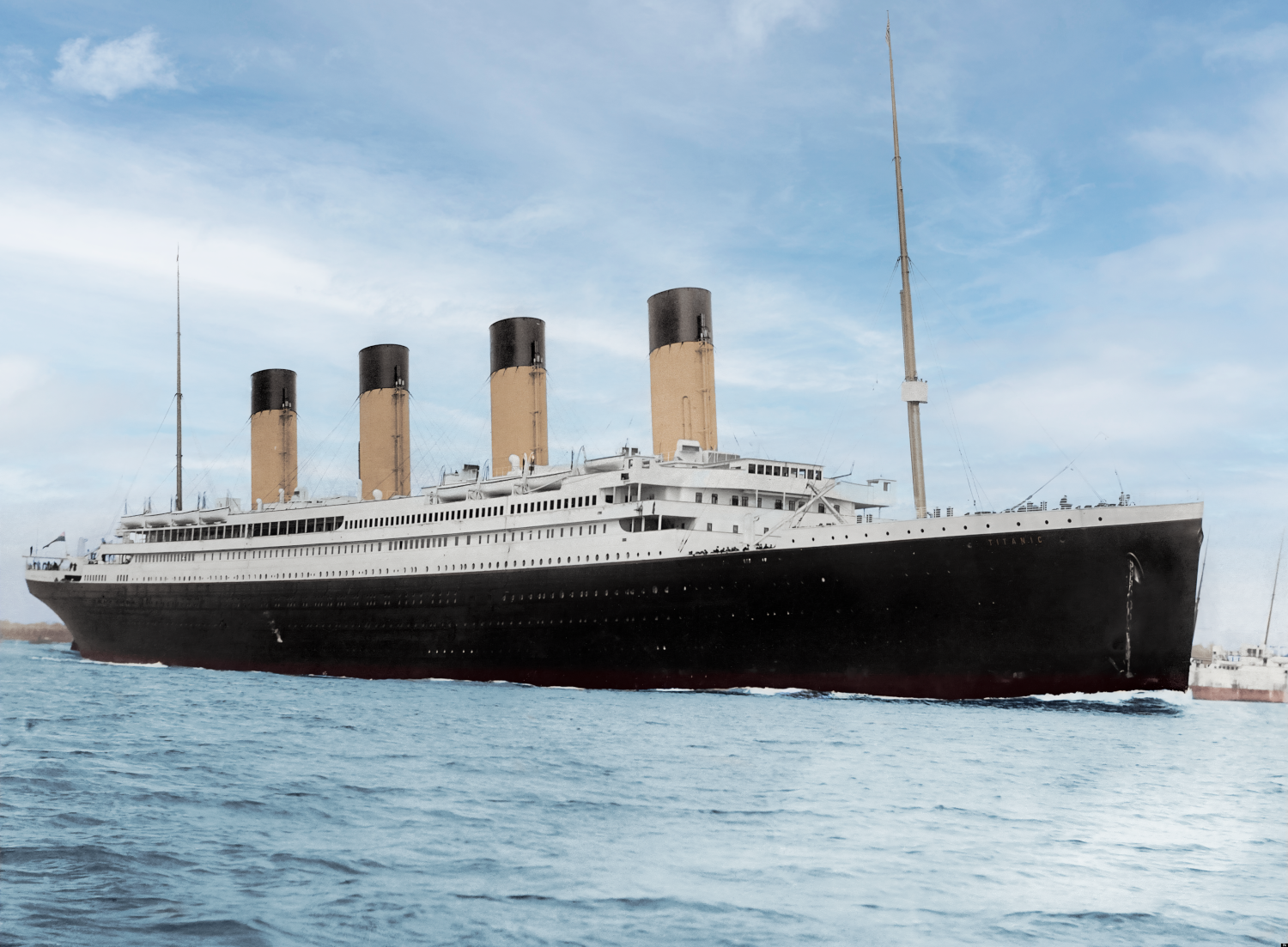 a large, four-masted, black cruise ship sailing on the water.