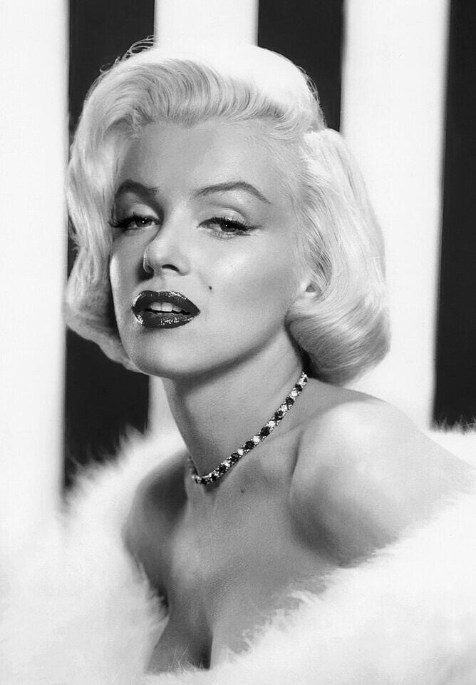 A black and white portrait of a woman with blonde hair wearing a fur coat and a necklace.