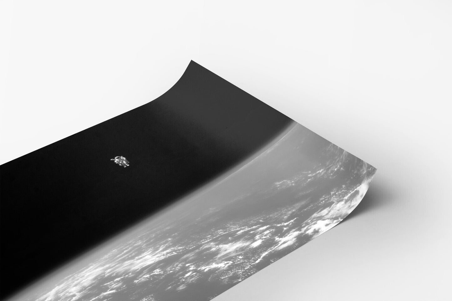 A black and white image depicting a small space shuttle or spacecraft in the sky, with the Earth visible below.