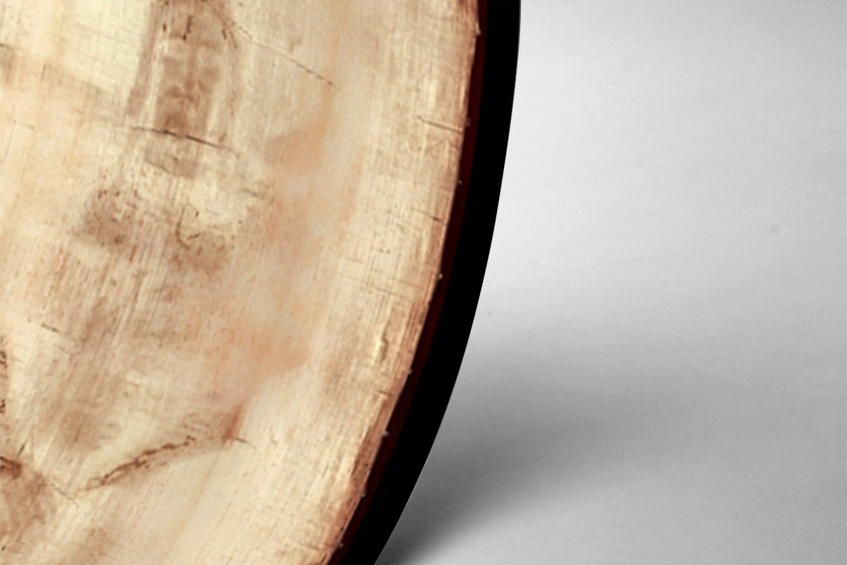 a close-up view of a wooden surface with a dark border, likely a piece of furniture or a decorative item.