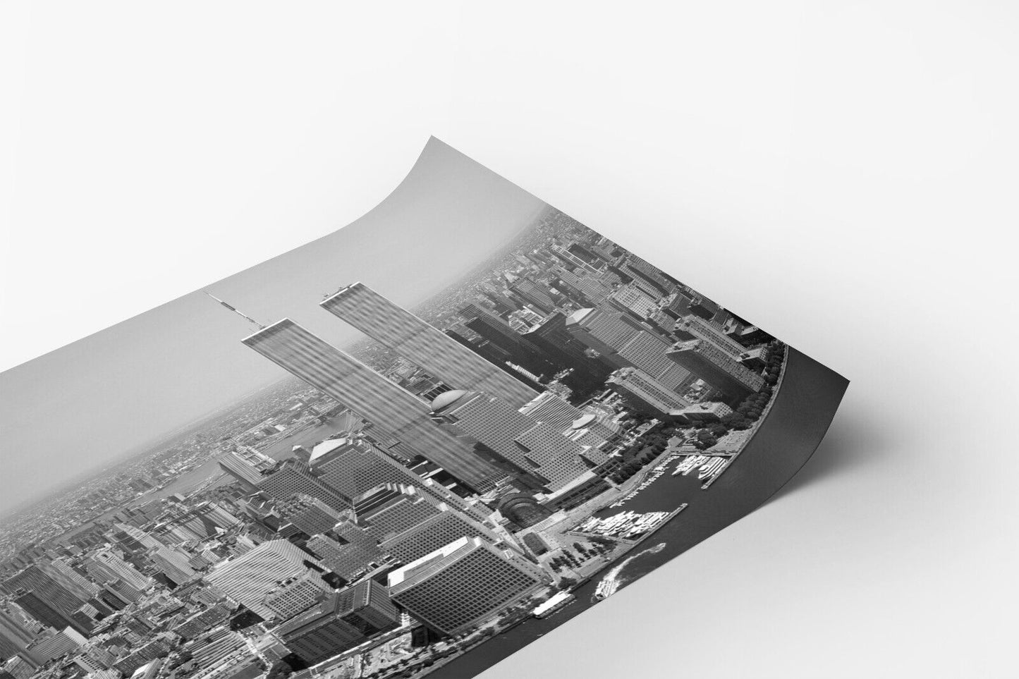 A black and white aerial view of a densely populated city, with tall skyscrapers and buildings stretching out into the distance.