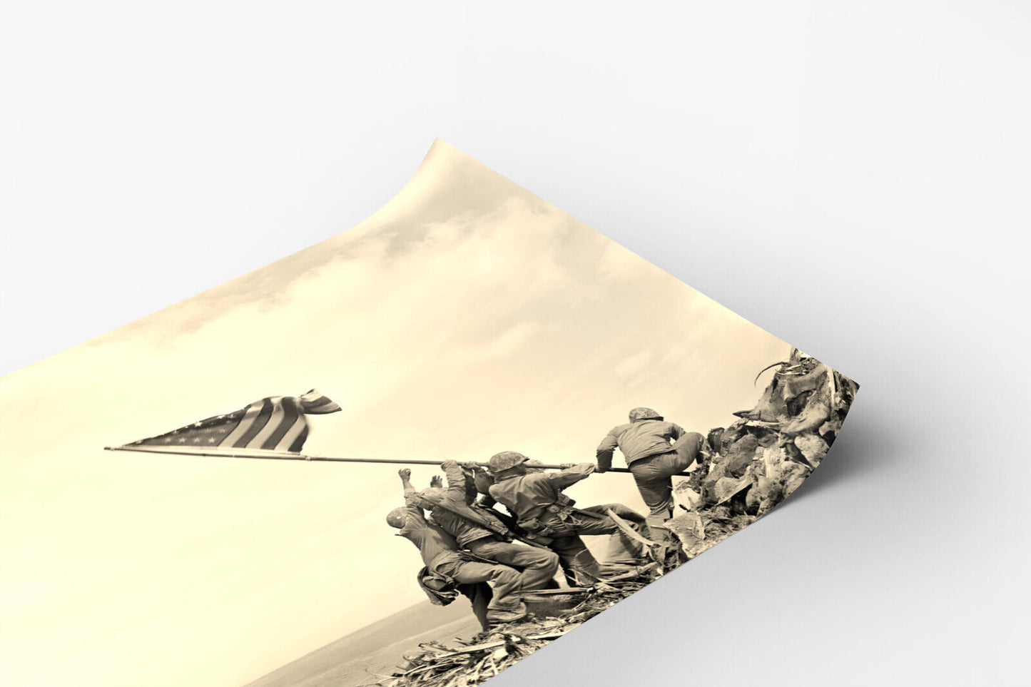 A black and white photograph of soldiers raising an American flag on the beach, with a cloudy sky in the background.